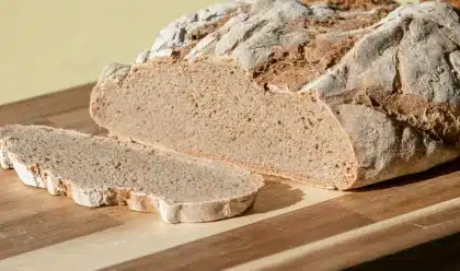 Grains de blé et farine saupoudrée sur une surface en bois en lumière naturelle