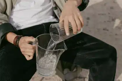 Personne tenant un verre d'eau pendant une journée très chaude et ensoleillée