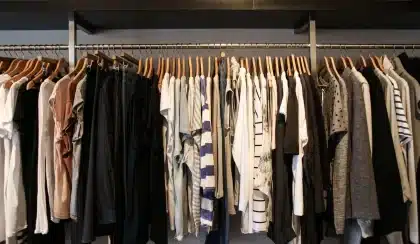 Tenues neutres et basiques de garde-robe disposées sur une surface claire