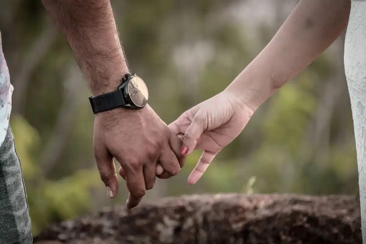 Deux mains enlacées dans une lumière douce, symbole de tendresse et de connexion émotionnelle