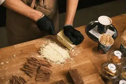 Mains versant du chocolat fondu dans un moule pour préparer une tablette maison
