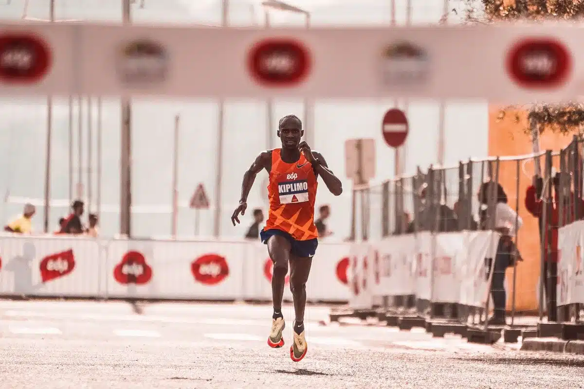 Coureur en sandales minimalistes sur une route longue et dégagée