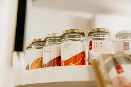 Mains anonymes examinant des produits alimentaires emballés sur une étagère de supermarché
