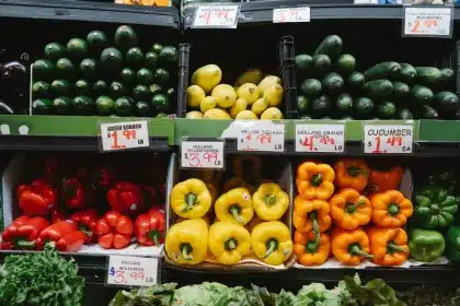 Mains comparant des produits alimentaires sur un rayon de supermarché avec étiquettes nutritionnelles visibles