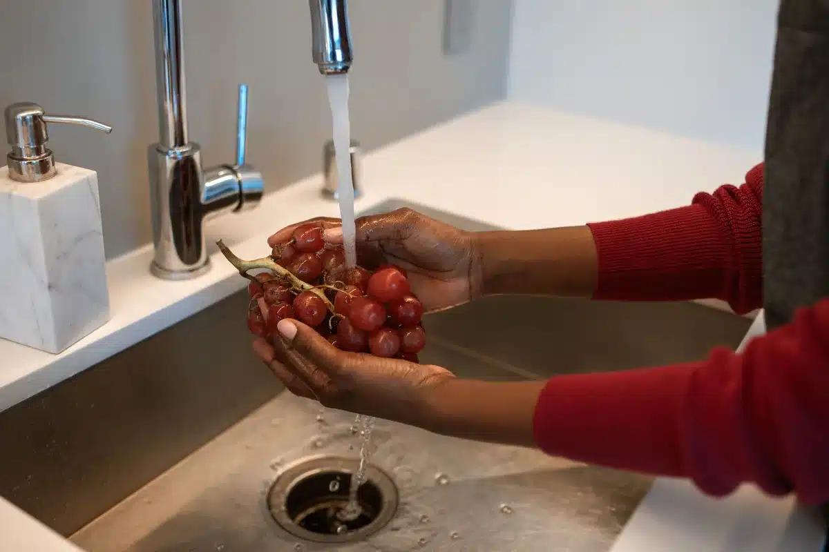 Mains rinçant une plaie sous l'eau tiède pour éliminer les débris
