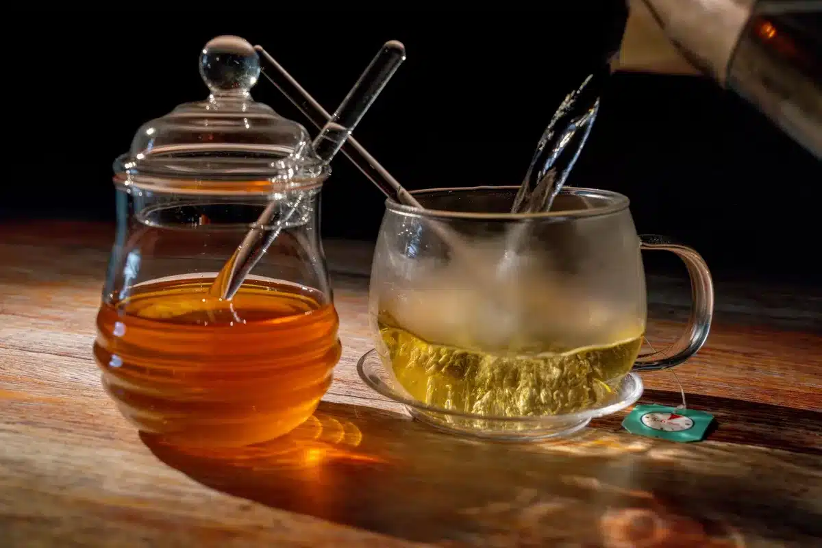 Trois pots contenant du miel, du sucre blanc et du sirop d'agave c&ocirc;te &agrave; c&ocirc;te