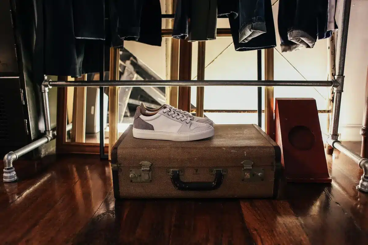 Paire de baskets blanches en cuir posée sur un sol neutre.