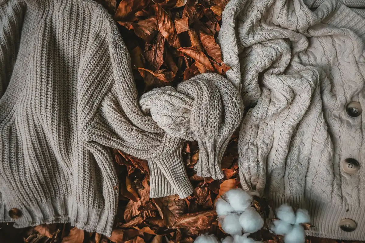 Pièces de mode d'automne superposées : blazer oversize, pantalon large, pull, accessoires et sneakers colorées.