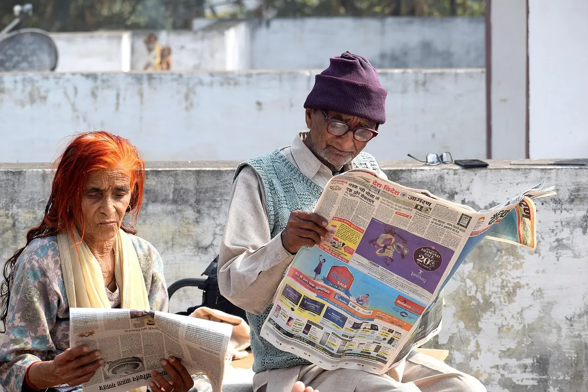 Couple discutant calmement à une table ensoleillée avec carnet et tasse