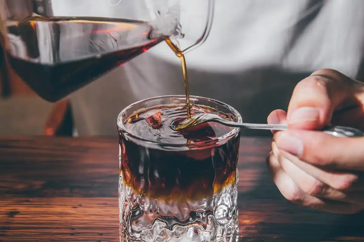 Bol en verre contenant de l'argile verte préparée sur une table avec une cuillère
