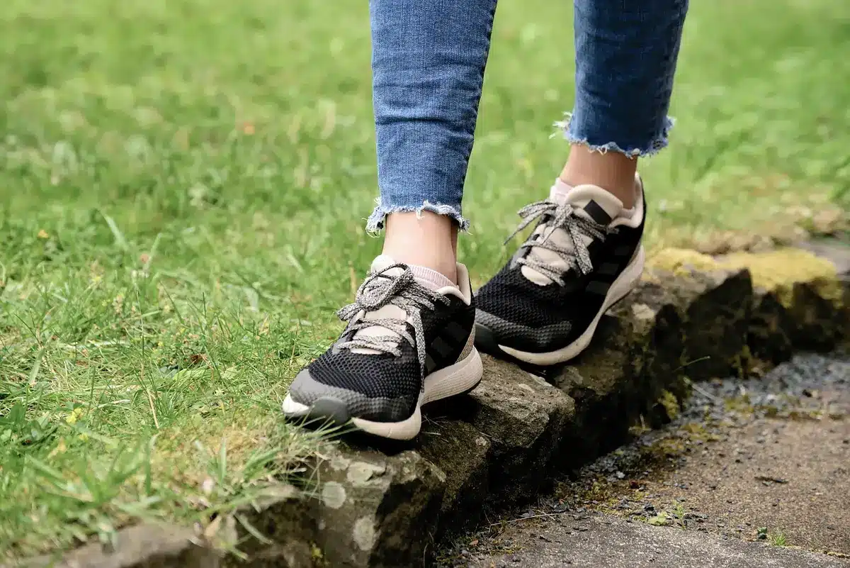 Personne changeant de chaussures en passant de sandales à des chaussures fermées, illustration de la transition de rentr