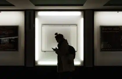 Silhouettes anonymes d'un couple tournés l'un de l'autre dans une chambre, lumière douce