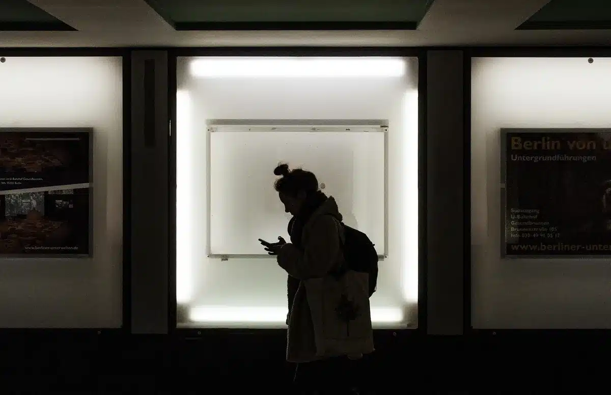 Silhouettes anonymes d'un couple tournés l'un de l'autre dans une chambre, lumière douce