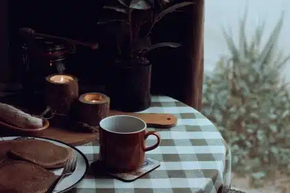 Deux mains qui se rejoignent sur une table le matin avec des tasses de café et une lumière douce