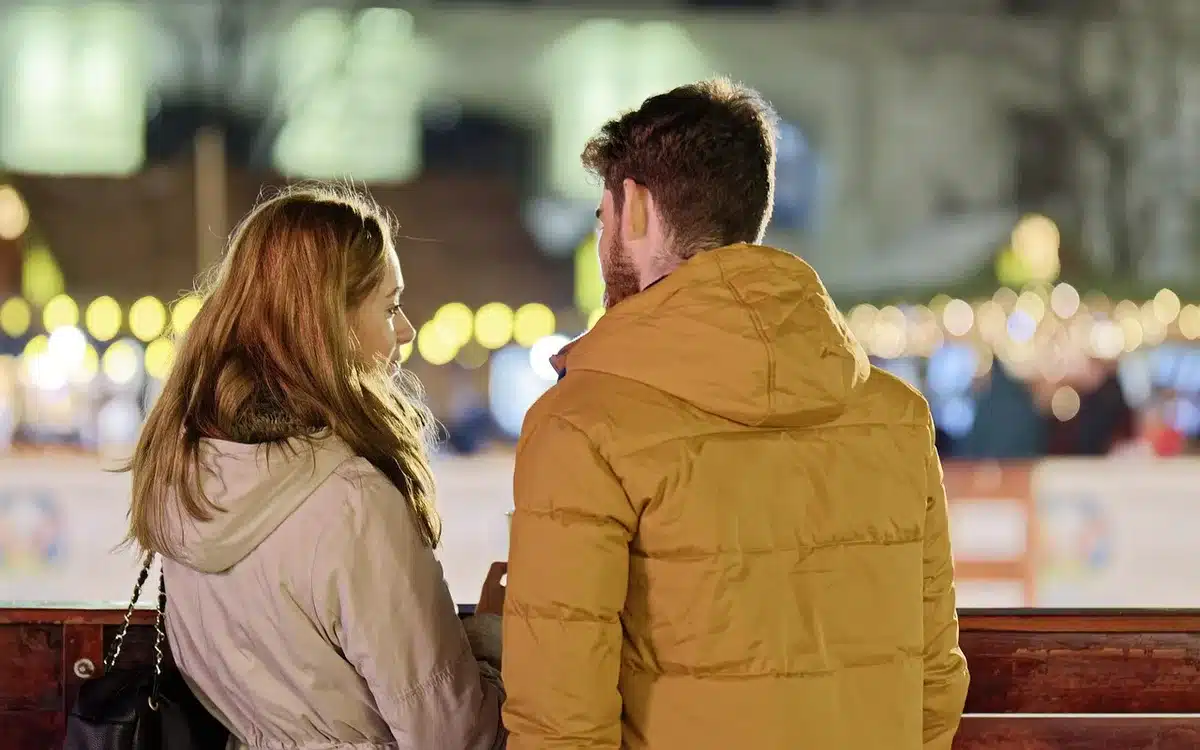 Couple discutant dans un salon lumineux, échange attentif