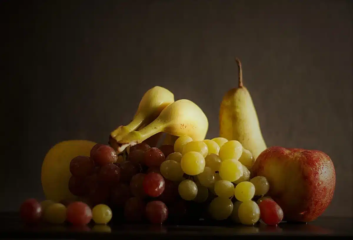 Pommes et bananes côte à côte sur une planche, illustrant fruits climactériques