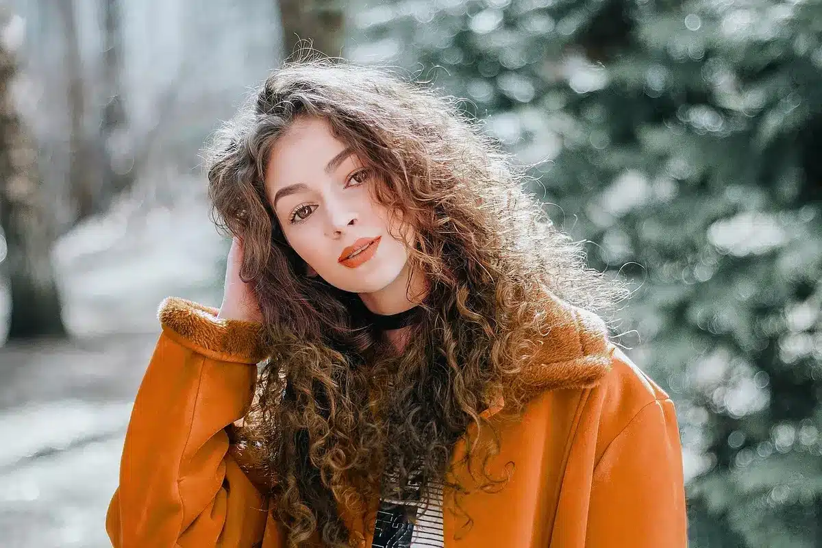 Femme portant une salopette vintage associ&eacute;e &agrave; un blazer camel et des mules, d&eacute;montrant l'adaptation du vintage au quoti