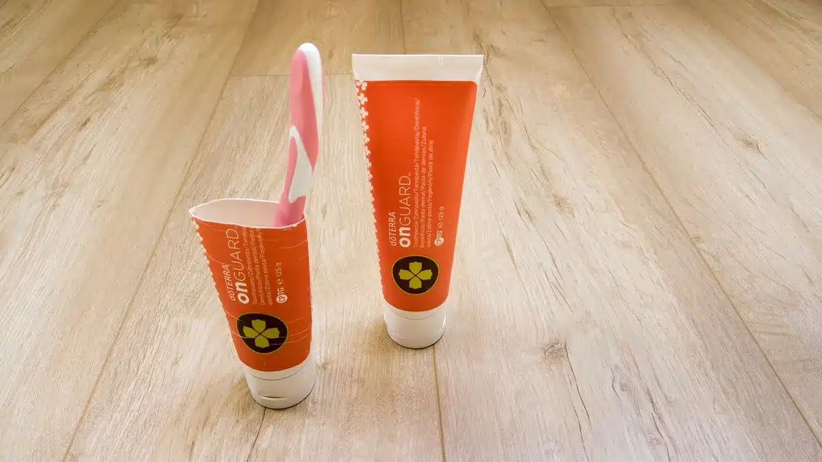 Brosse à dents à poils souples et dentifrice fluoré près d'un lavabo en plein jour