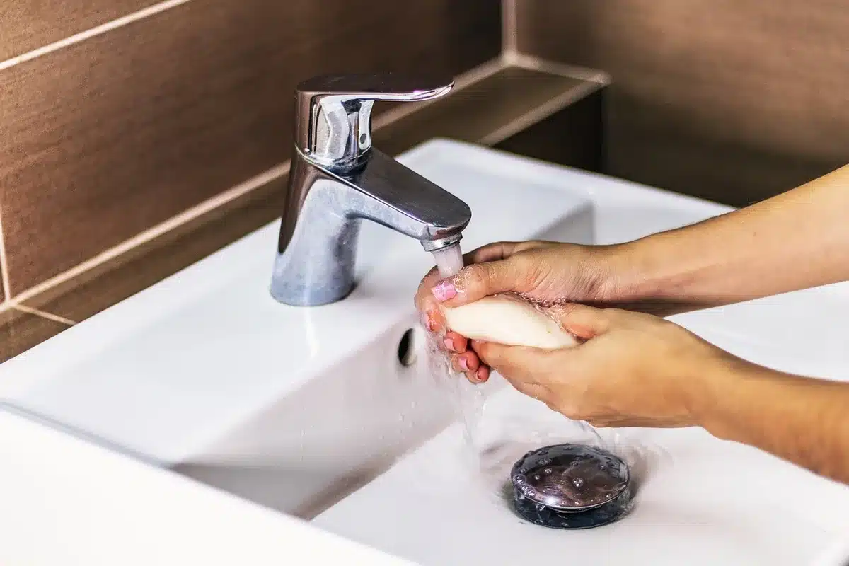 Nettoyage d'une prothèse dentaire au lavabo en pleine journée
