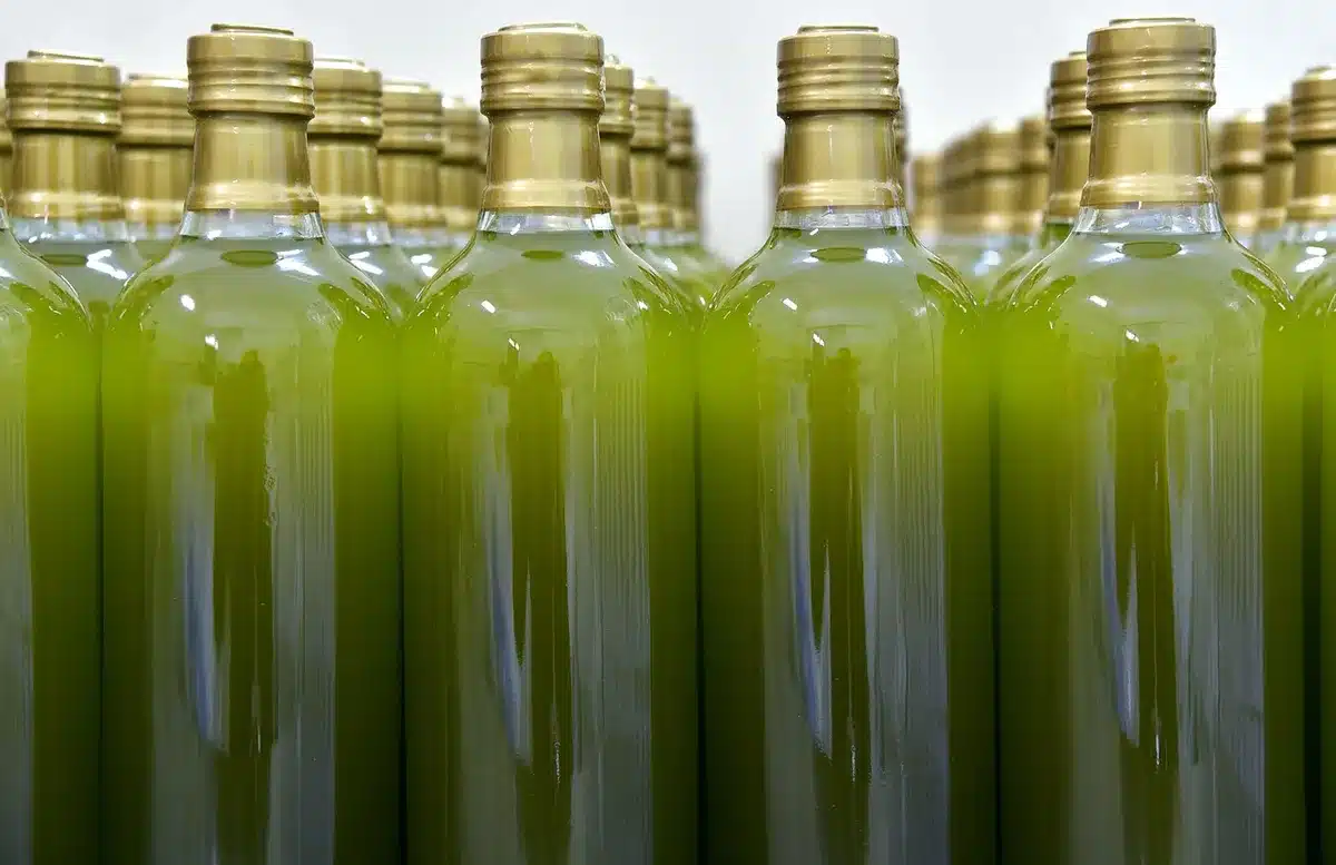 Bouteille d'huile d'olive et petit bol de noix sur une table de cuisine