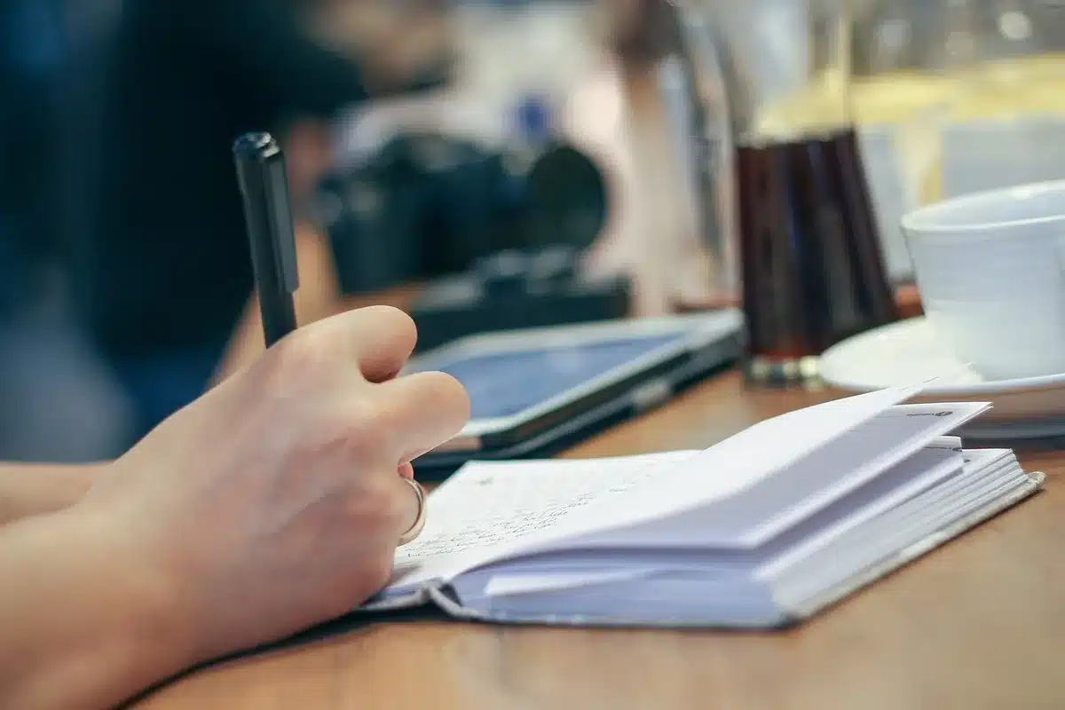 Deux personnes autour d'un carnet de budget et d'une calculatrice près d'une fenêtre