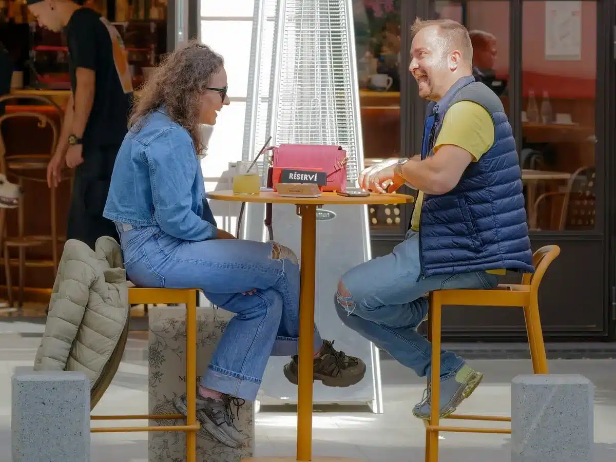 Deux personnes assises à une table discutant calmement en pleine journée