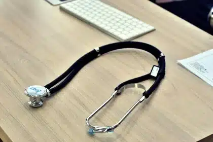 Mains tenant un dossier médical et une image d'échographie cardiaque près d'une fenêtre en journée